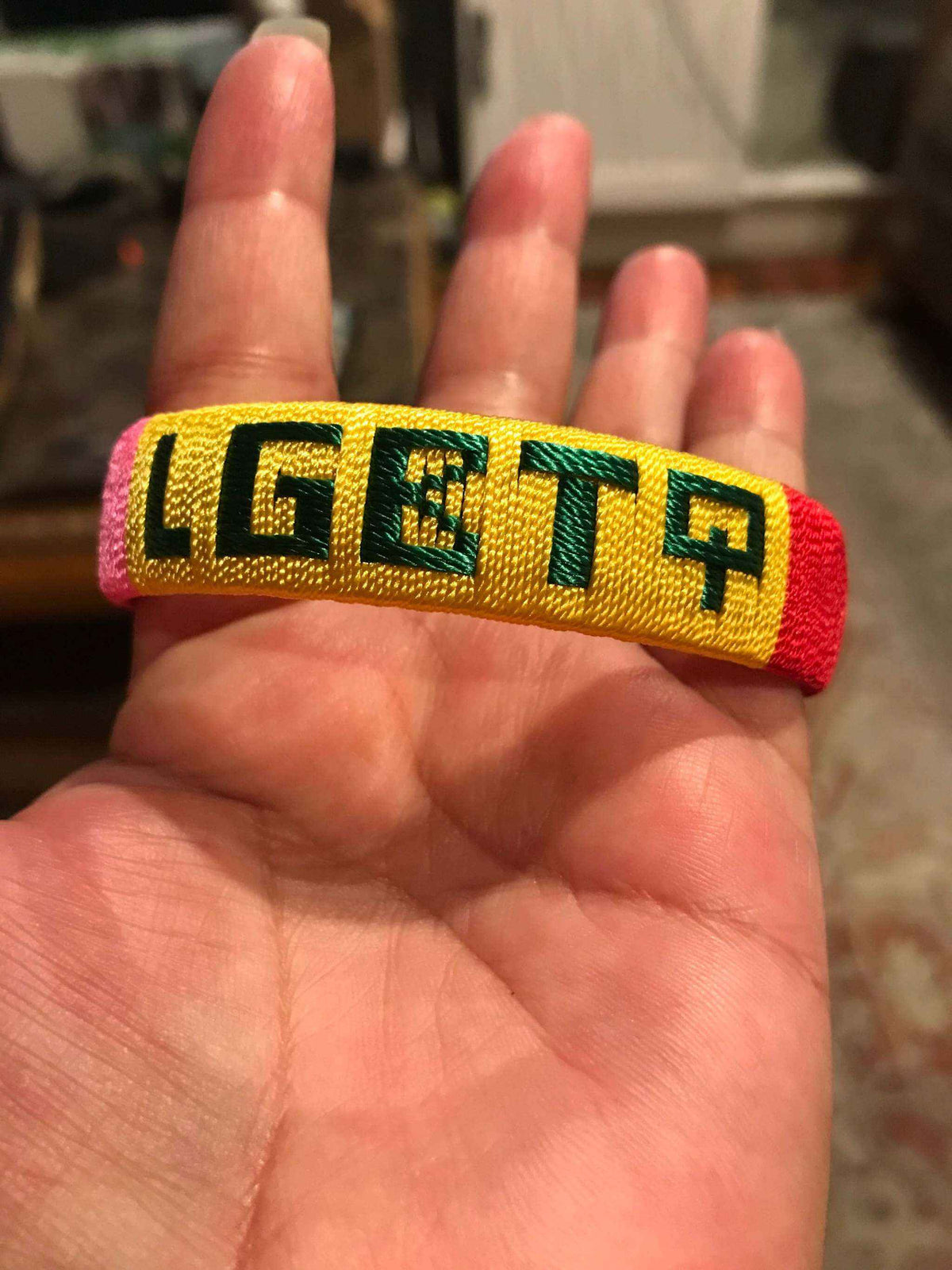 LGBTQ Pride Bracelet in hand, featuring vibrant rainbow design for support and empowerment.
