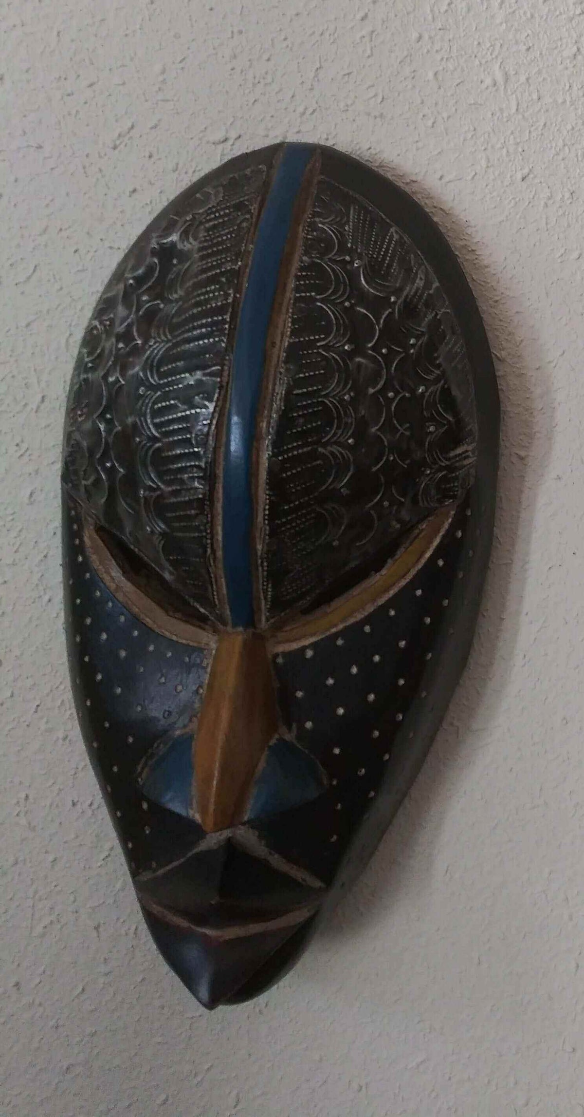 Handcrafted African tribal mask with intricate carved patterns and bold design representing cultural heritage and tradition