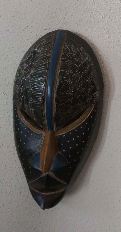 Handcrafted African tribal mask with intricate carved patterns and bold design representing cultural heritage and tradition